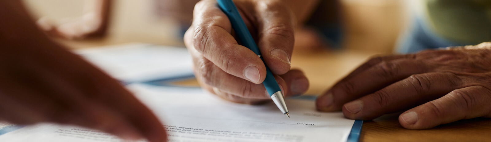 closeup of person signing a form