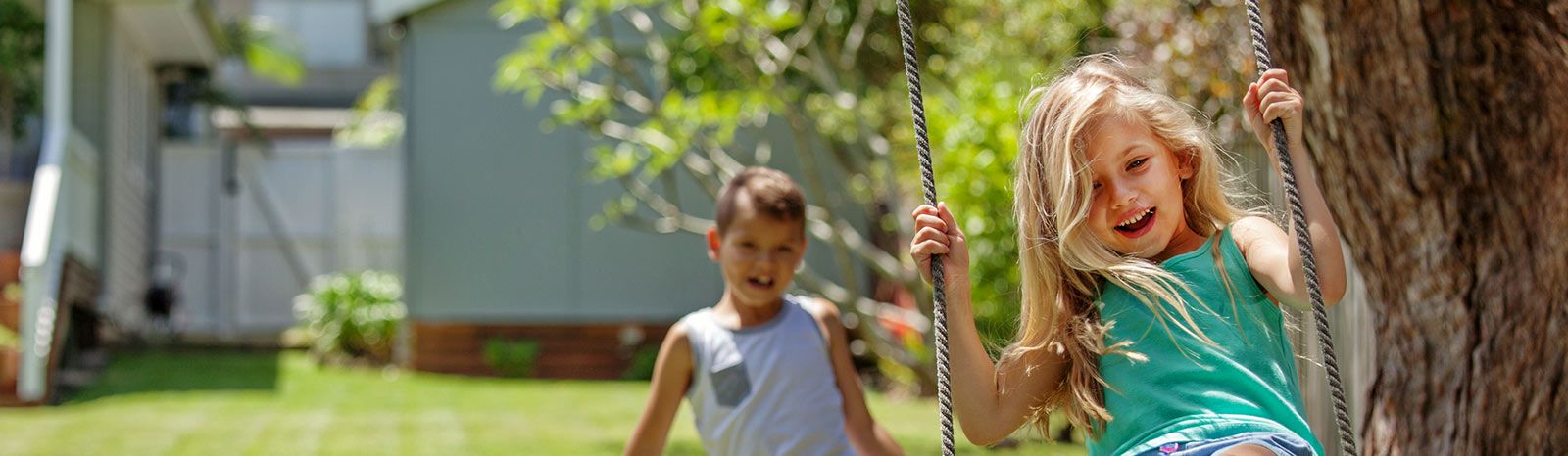 children swinging in yard