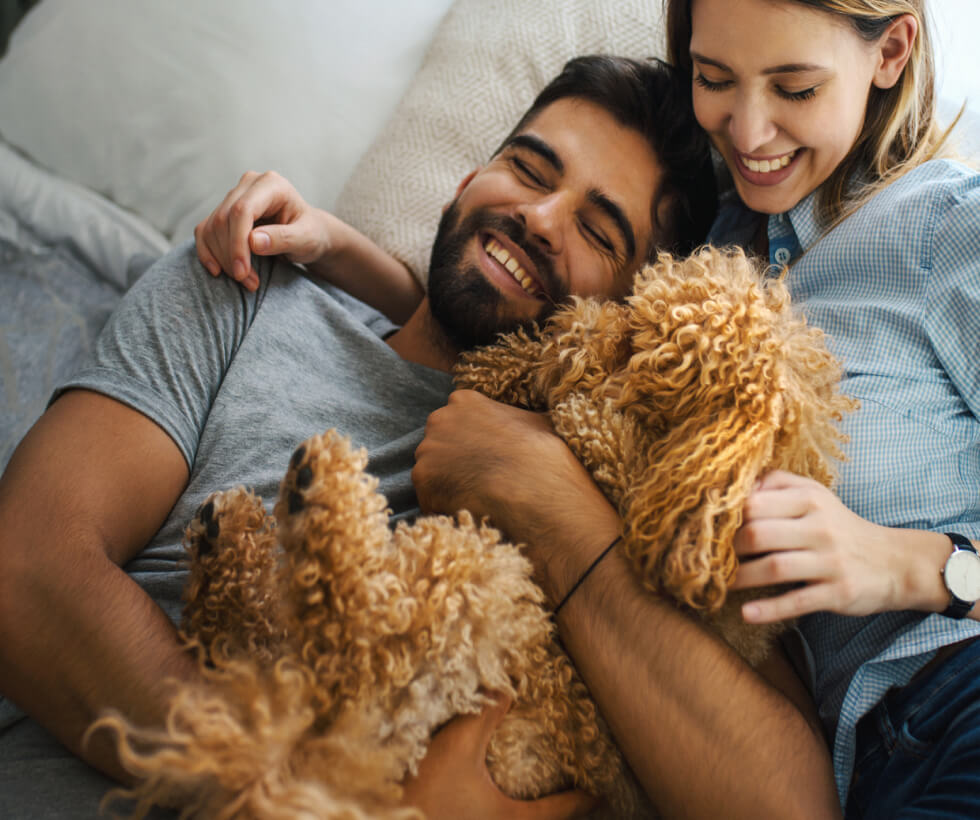 Young couple cuddling dog